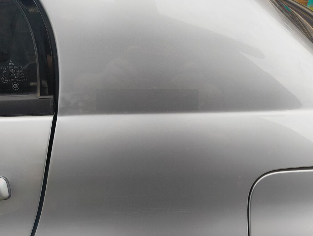 Rear quarter shows badge-removal ghosting near the fuel filler